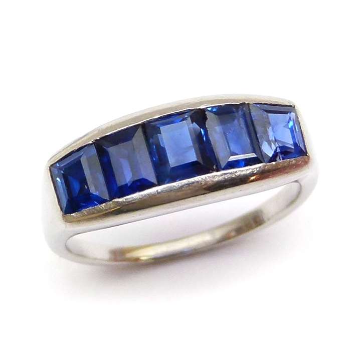 Platinum mounted plain half hoop ring with five rectangular cut sapphires